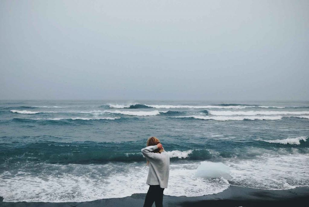 woman walking along the shore during low tide