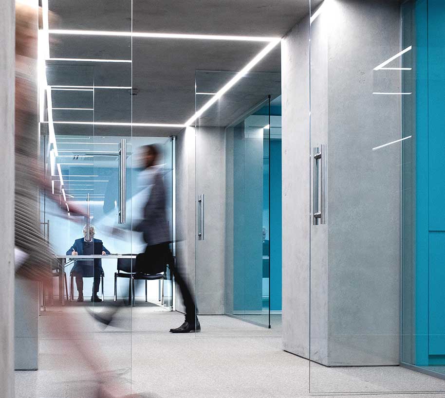 blurred image of man walking fast in an office