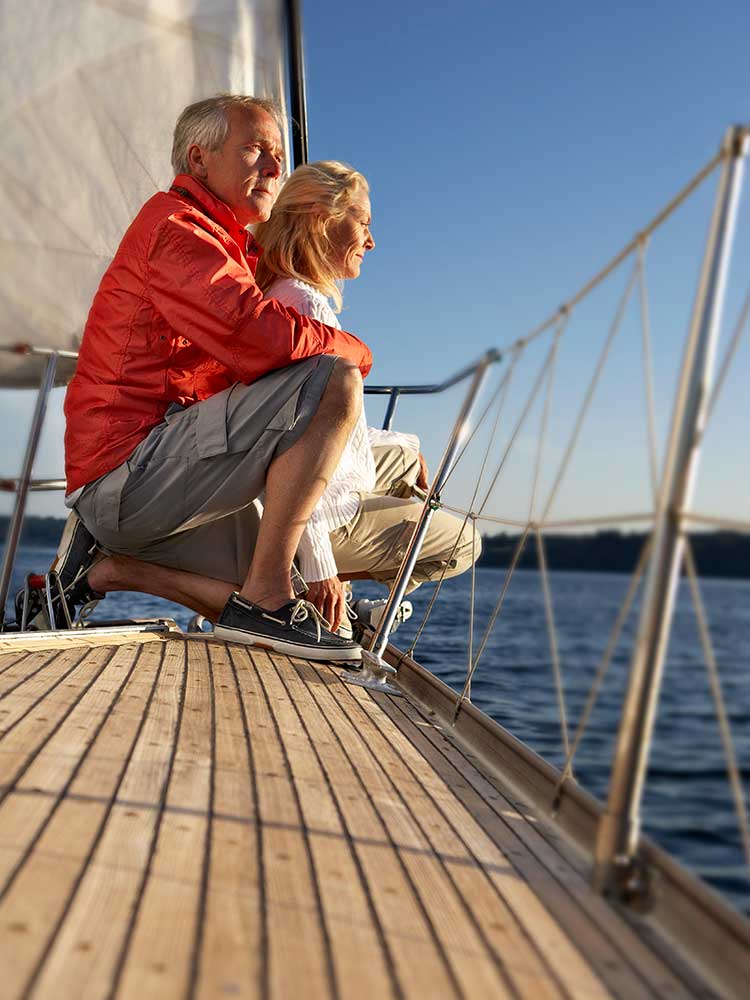 older couple on a sailboat staring out to sea