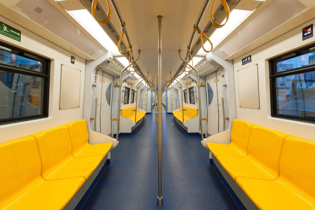 Inside of a subway car with yellow seats